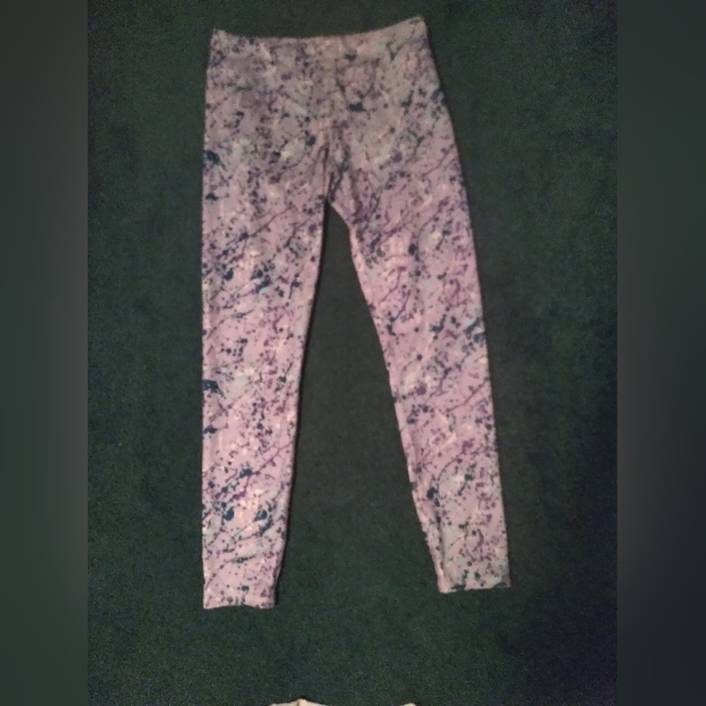Purple active wear pants where the design looks like paint splatter marks